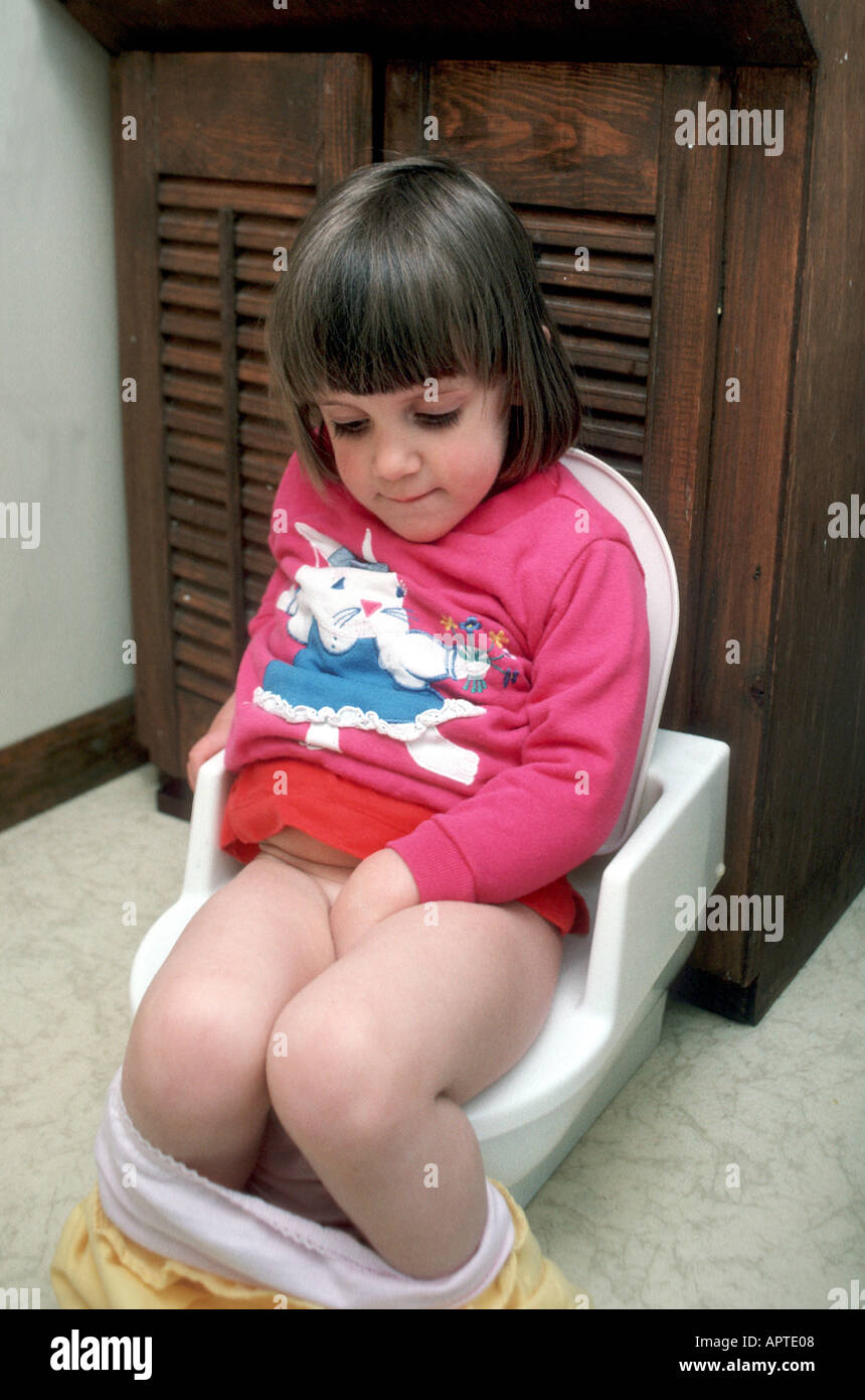 2 Jahre altes Mädchen auf kleine Toilette sitzt, wie sie Töpfchen wird geschult Stockfoto