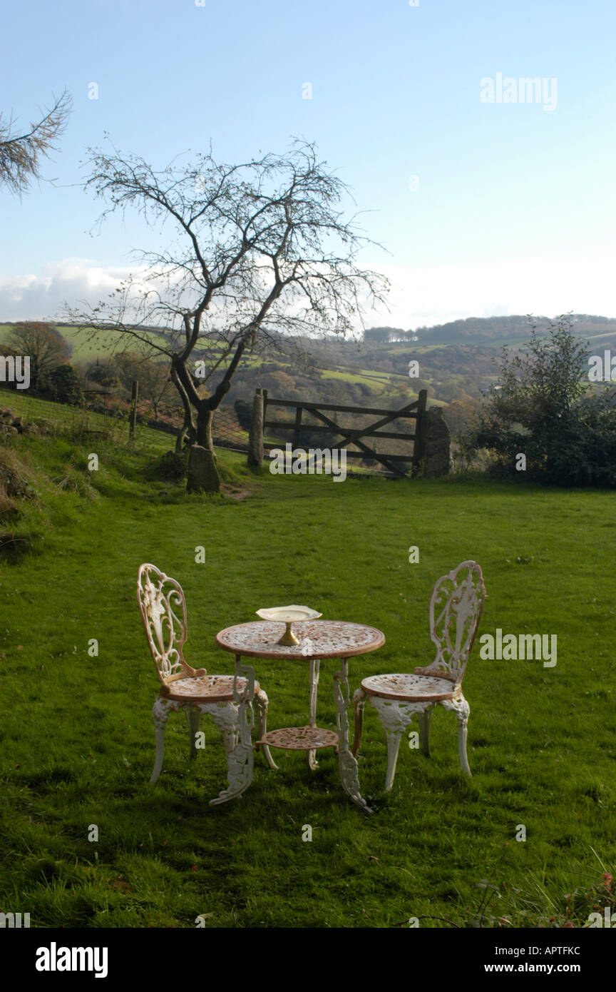 Gartenmöbel in einen Garten mit Blick auf die Devon-Landschaft im Hintergrund, leere Kuchen stehen auf dem Tisch. Stockfoto