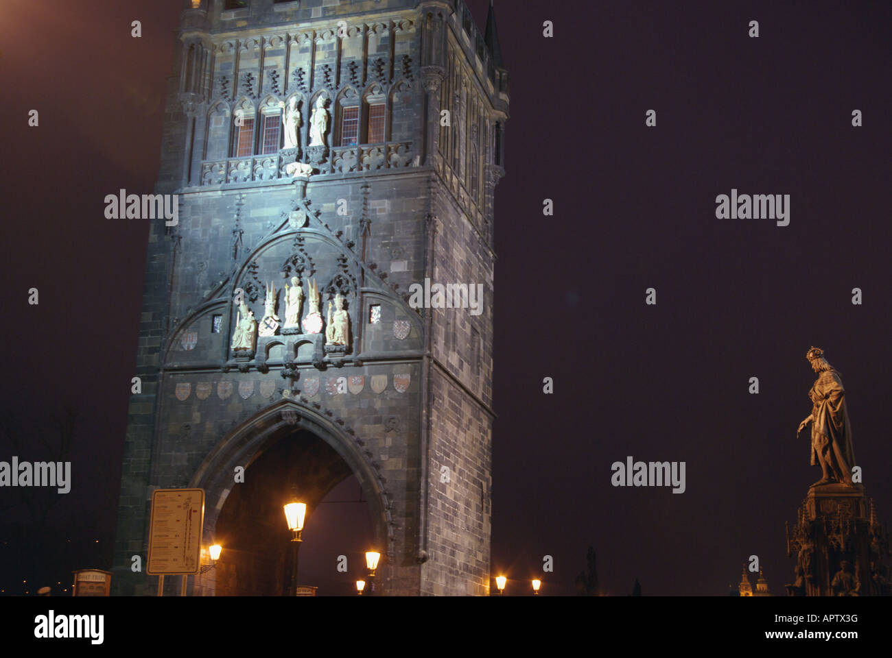 Blau beleuchtet Charles Bridge Tower und Statue von Charles IV in der Nacht. Stockfoto