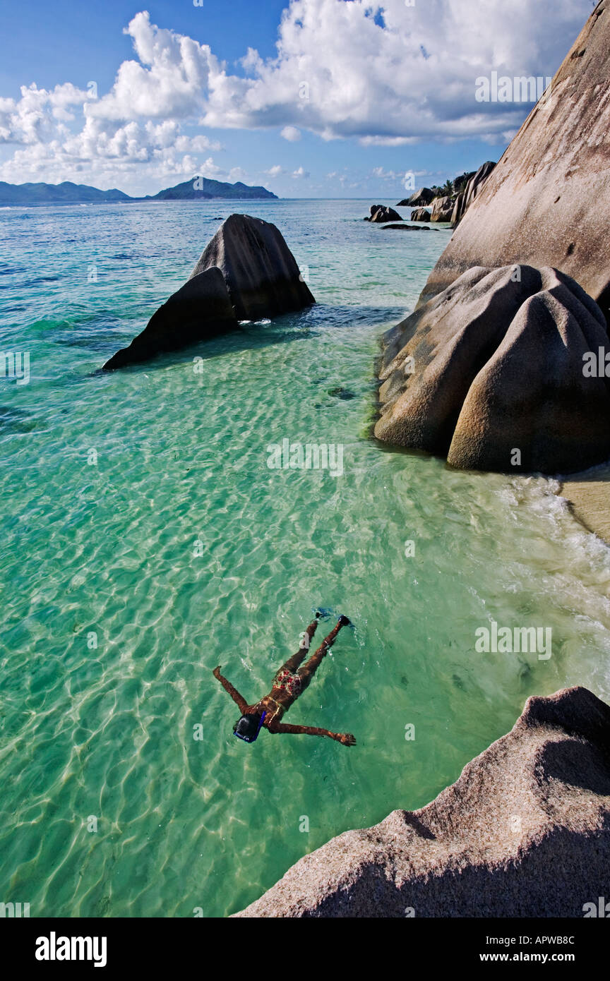 Frau Schnorcheln im klaren Wasser unter Granit Findlinge Modell freigegeben Anse Source d Argent Strand La Digue Island-Seychellen Stockfoto