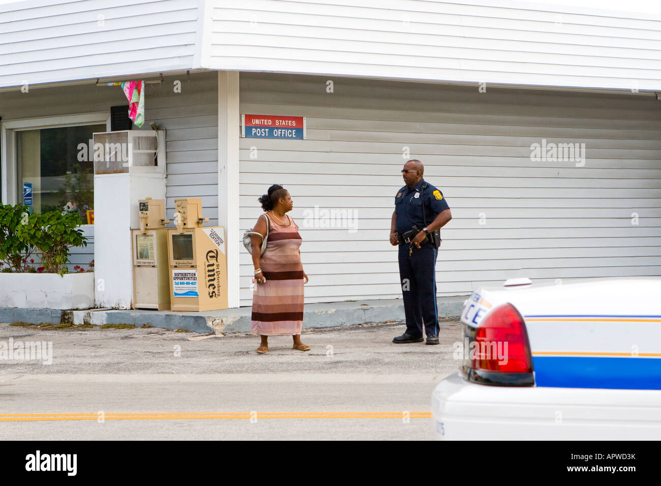 Afroamerikanischer schwarzer Polizist im Gespräch mit einer schwarzen Frau an einer Straßenecke in einer Begegnung mit einer nicht-konfrontativen Nachbarschaft Stockfoto