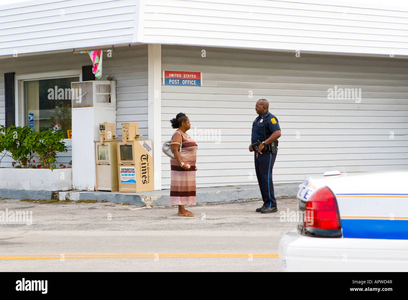 Afroamerikanischer schwarzer Polizist im Gespräch mit einer schwarzen Frau an einer Straßenecke in einer Begegnung mit einer nicht-konfrontativen Nachbarschaft Stockfoto