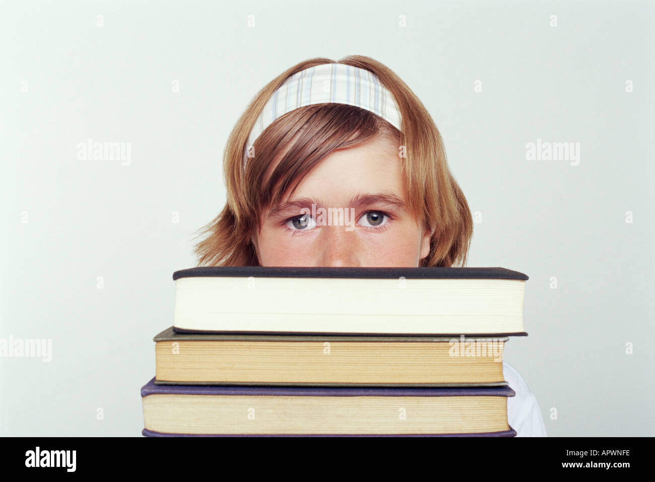 Mädchen hält einen Stapel Bücher Stockfoto