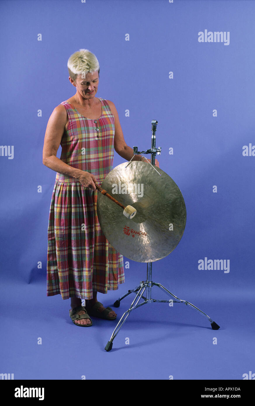 Eine Frau spielt einen gong Stockfoto