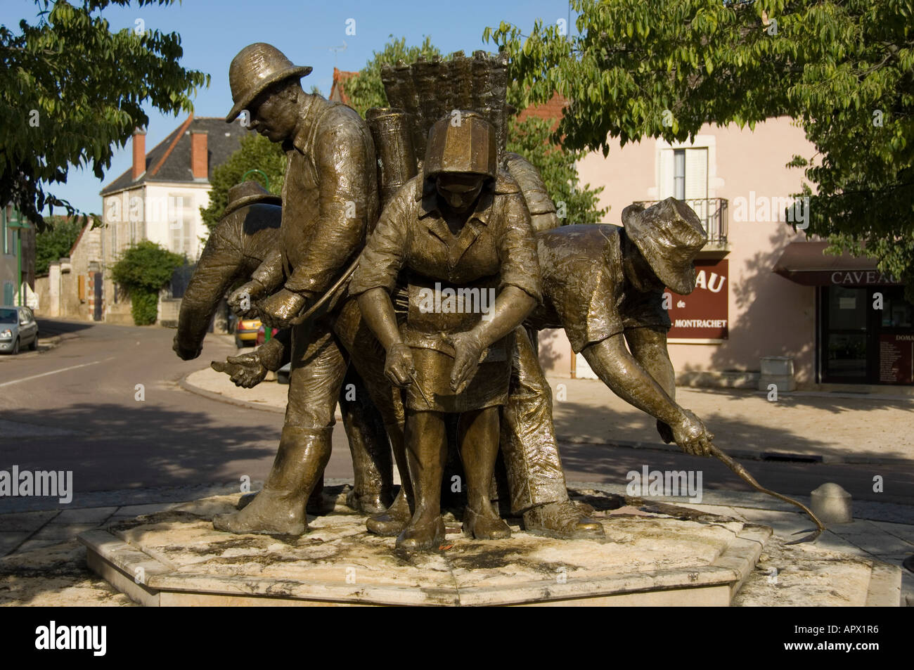 Statue von Trauben Erntemaschinen im Zentrum des Dorfes Puligny Montrachet, Burgund, Frankreich Stockfoto