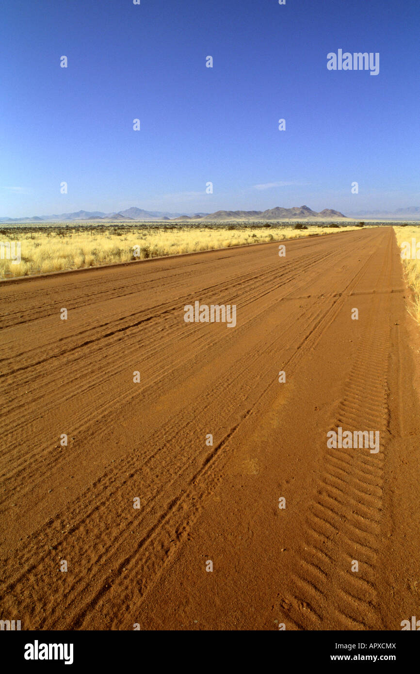 Eine lange, flache und gerade Sand Straße erstreckt sich bis zum Horizont in der Nähe von Sossusvlei Stockfoto