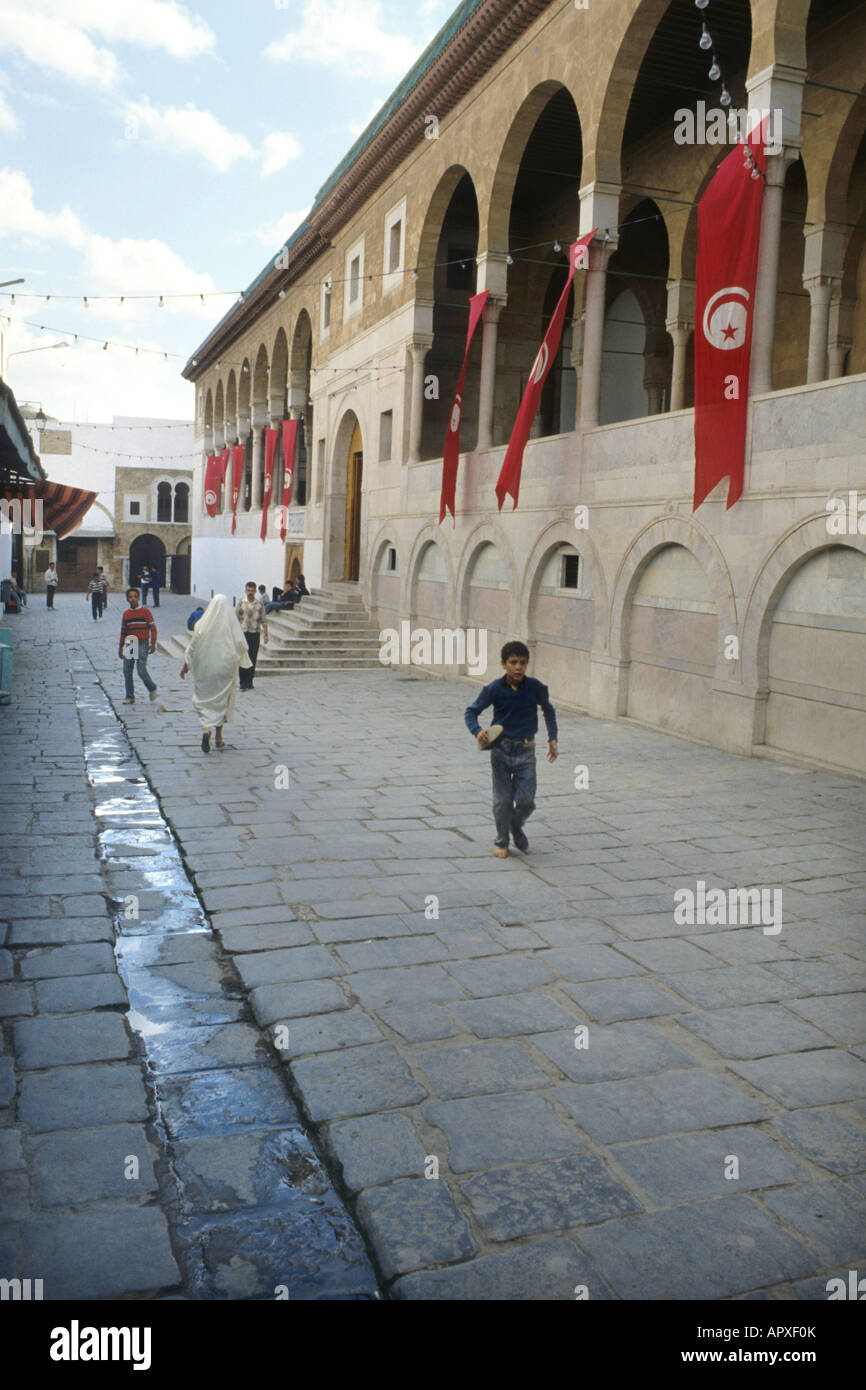 Menschen zu Fuß vorbei an der Moschee von Tunis Stockfoto
