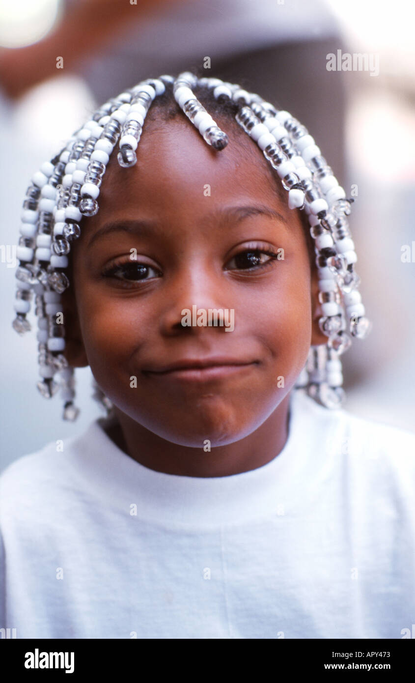 Junge schwarze Mädchen mit Perlen Haare und ein süßes und Cheecky Lächeln  Stockfotografie - Alamy