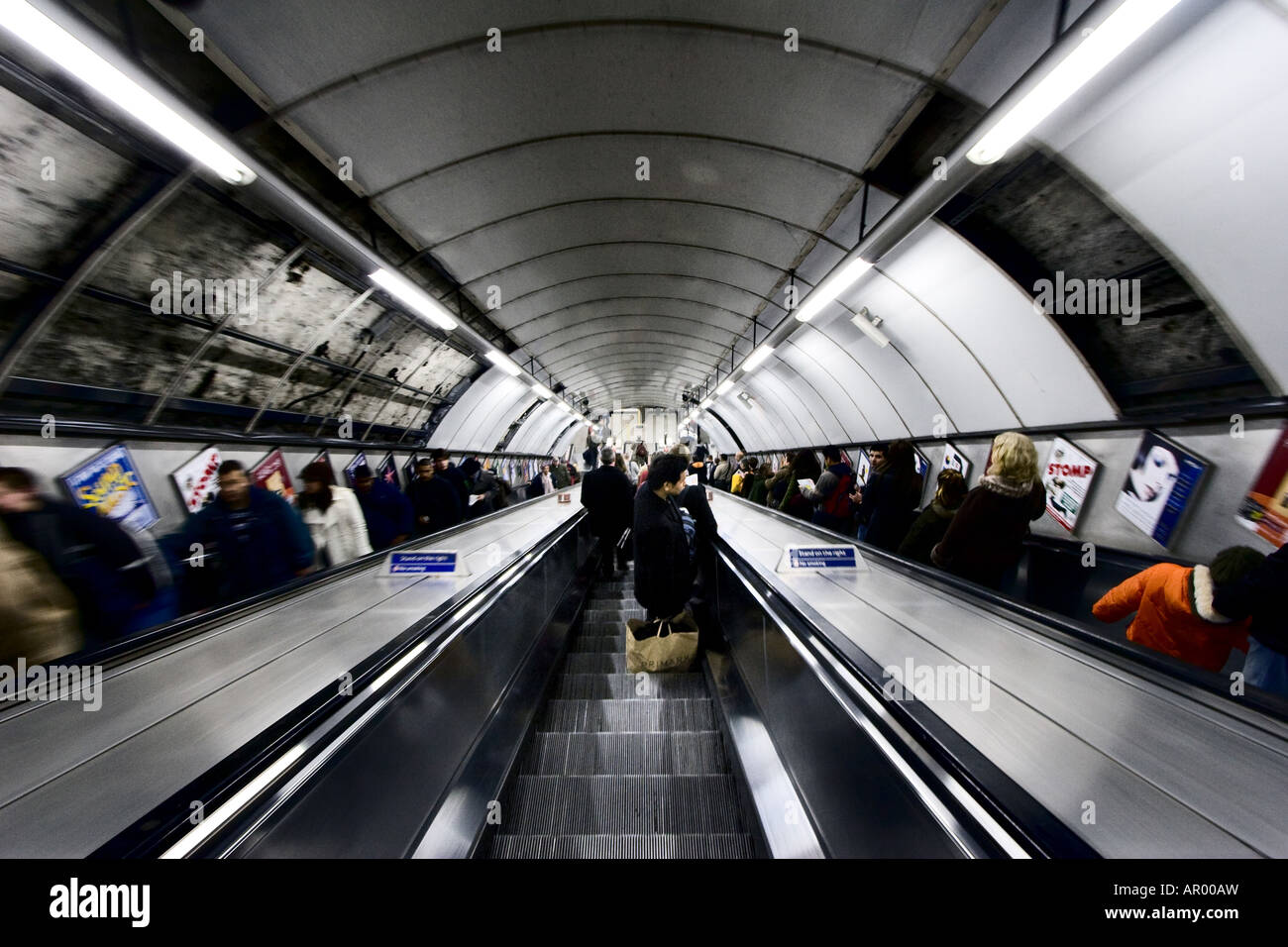 Menschen aufsteigen und absteigen Rolltreppen in der Londoner U-Bahn auch bekannt als The Tube in London UK 12 5 2007 Stockfoto