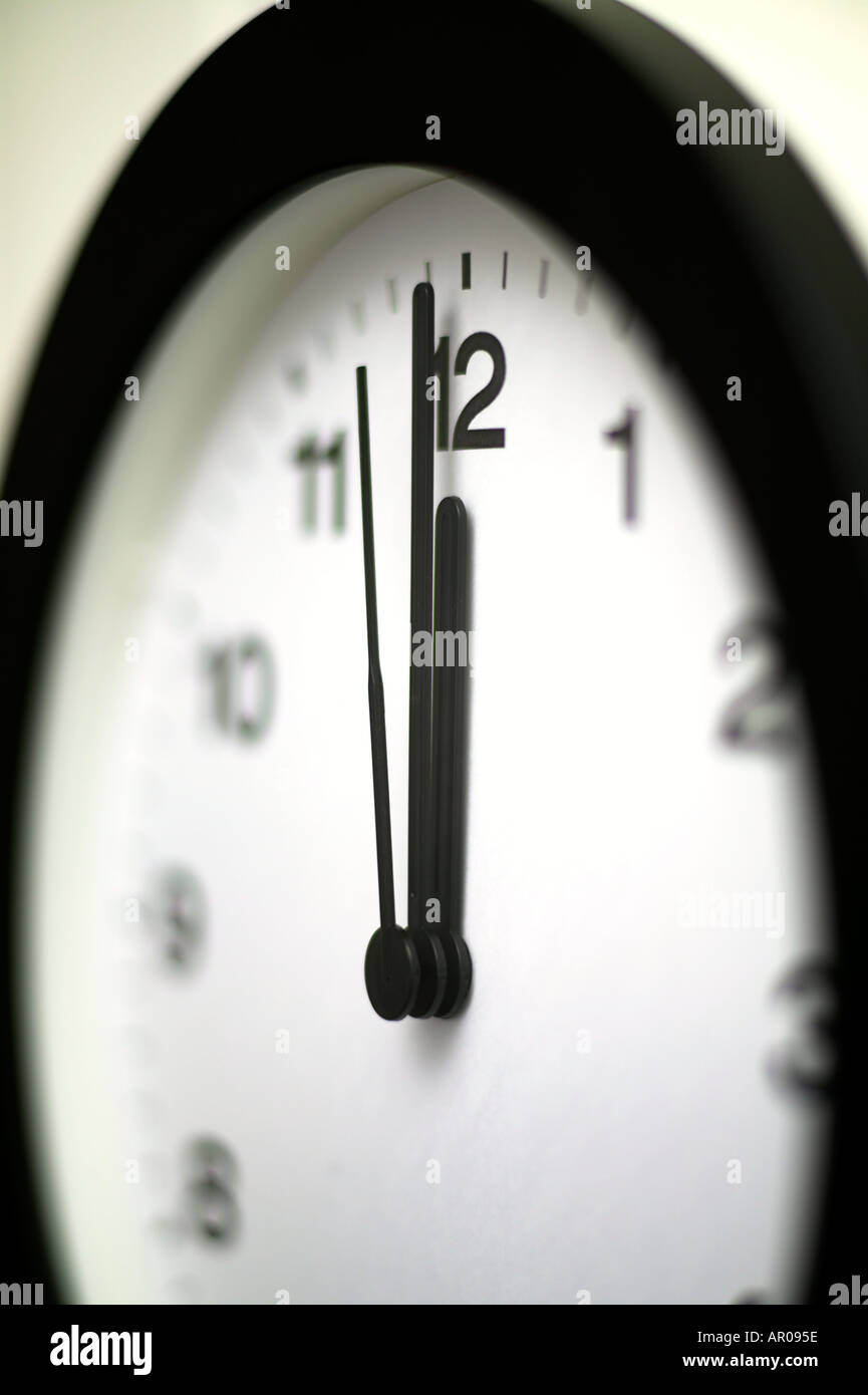 Nahaufnahme der Wanduhr mit einer Sekunde vor Mittag Mitternacht 1200 0000 Stockfoto