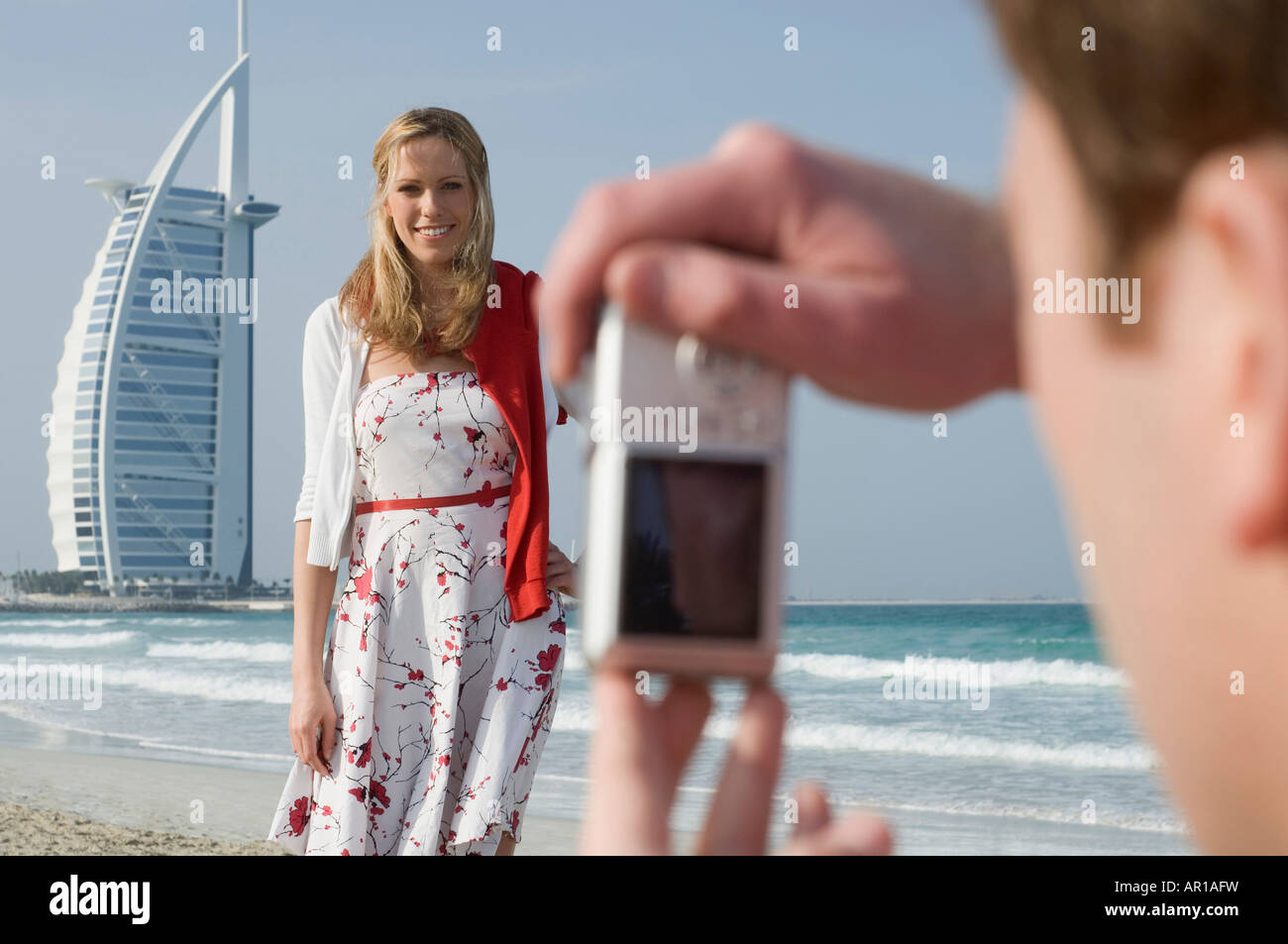 Paar sprechen Bilder am Strand, Dubai, Vereinigte Arabische Emirate Stockfoto
