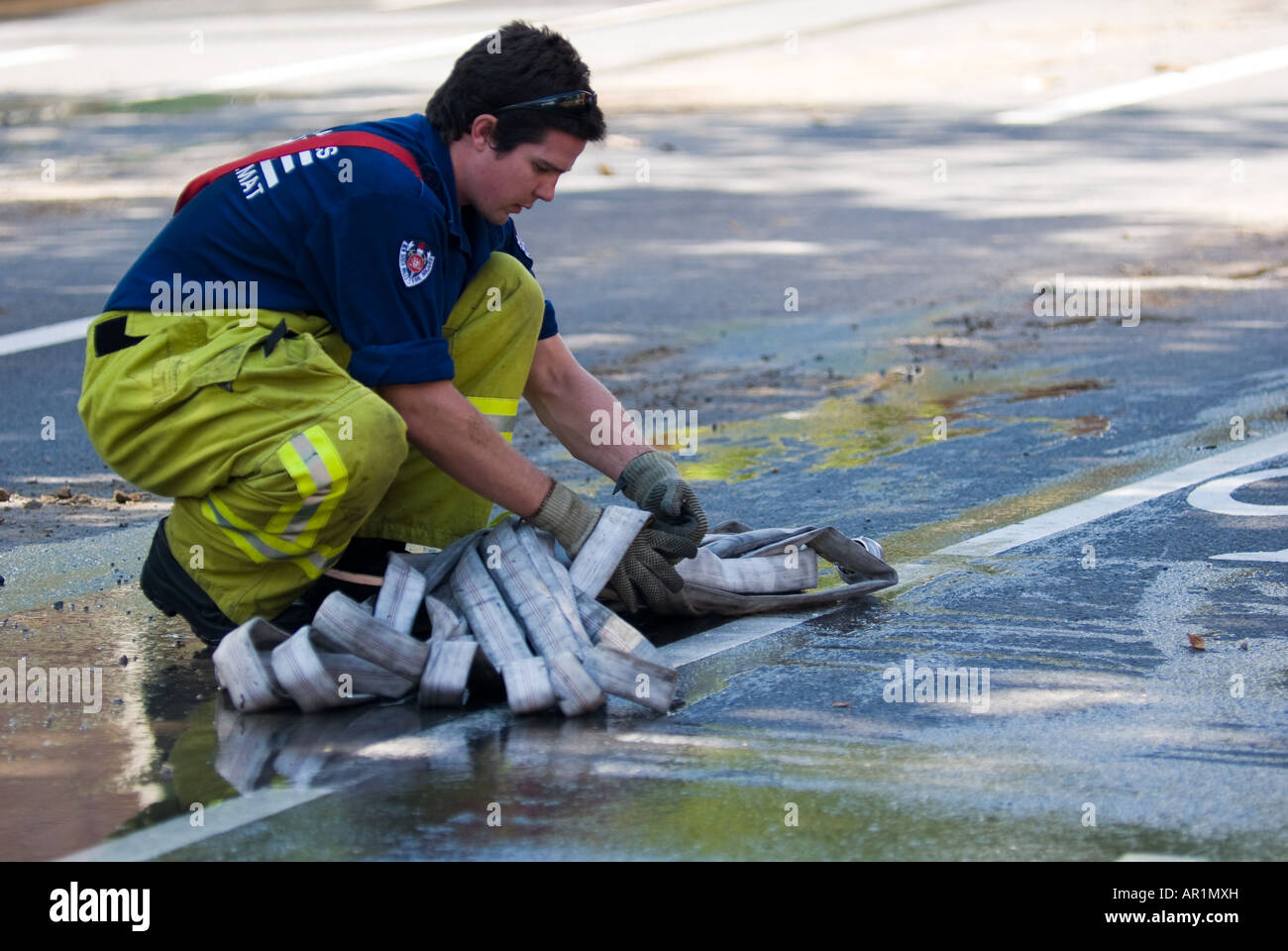 Fire Fighter am Arbeitsplatz Aufräumen nach dem Abriss eines Gebäudes Stockfoto