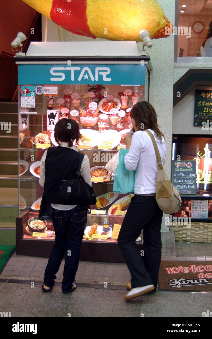 Zwei Frauen betrachten Kunststoff Repliken außerhalb Japans ein Restaurant Kyto Stockfoto