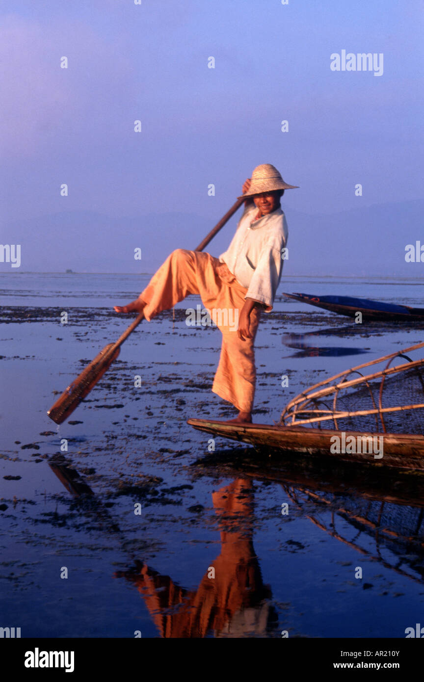 Birmanischer Fischer rudert mit seinem Bein auf dem Inle Lake, Myanmar Stockfoto