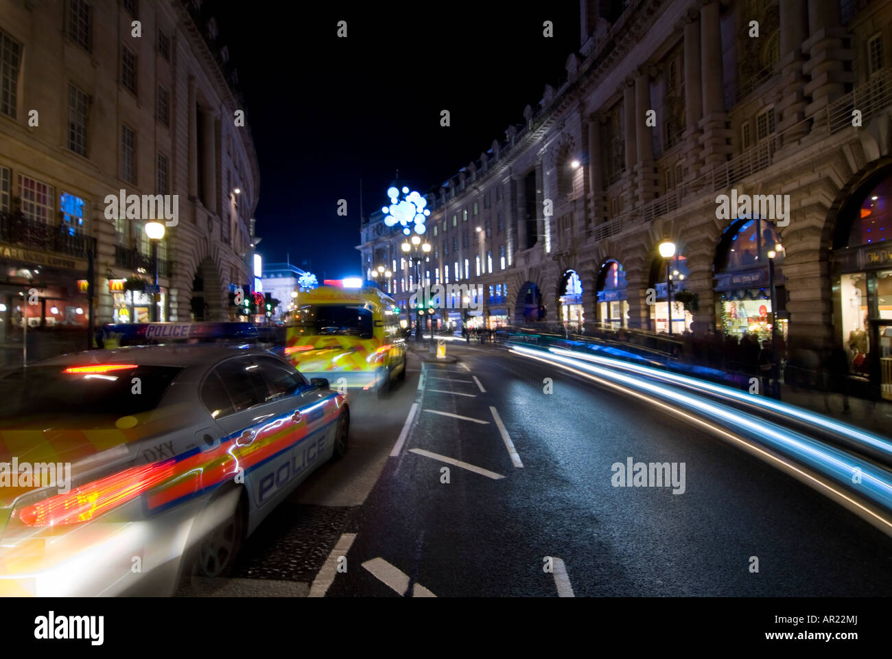 Horizontalen Weitwinkel von Regent St im Zentrum von London in der Nacht - ein Polizeiauto und Krankenwagen Zoomen bestanden in einer Unschärfe der Lichter. Stockfoto