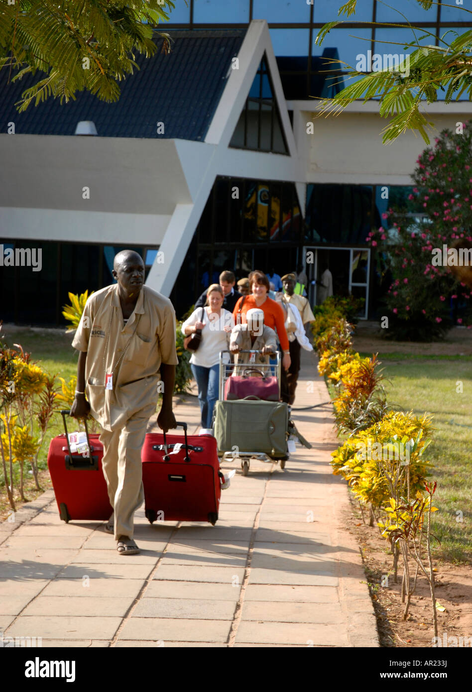 DZP Touristen kommen am Flughafen Banjul geholfen von Gepäckträgern Gambia Dez 2007 Stockfoto