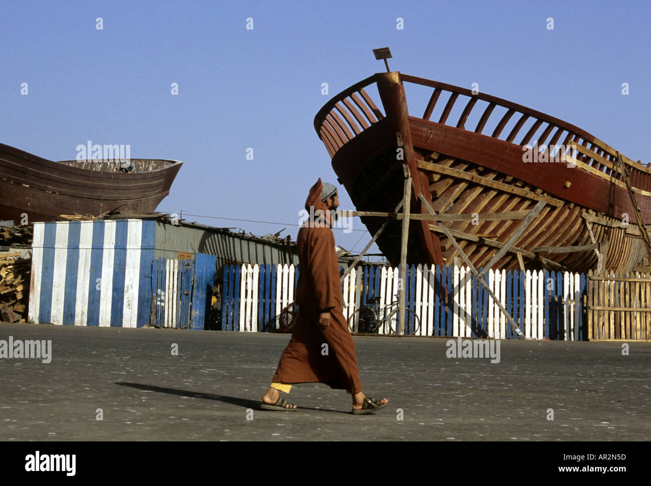 Mann zu Fuß vorbei an Werft im Hafen von Essaouira, Marokko. Stockfoto