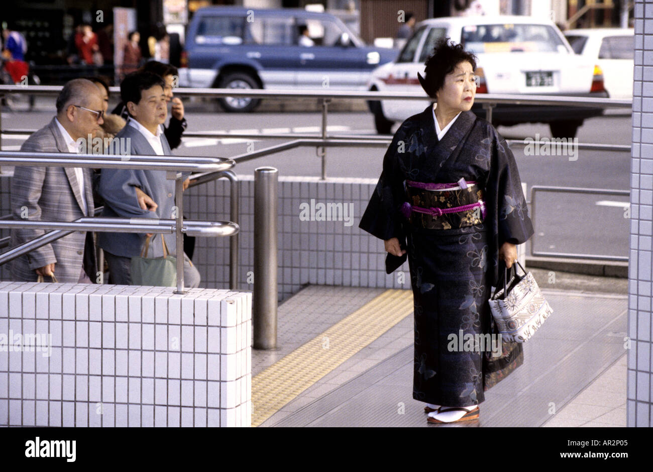 Frau im Kimono und typische Sandalen stehen außerhalb der u-Bahn Station, Zentrum von Kyoto, Japan. Stockfoto