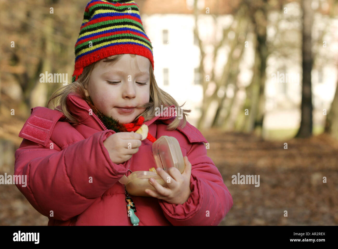 kleines Mädchen mit einem Stück von einem Apfel in der hand Stockfoto