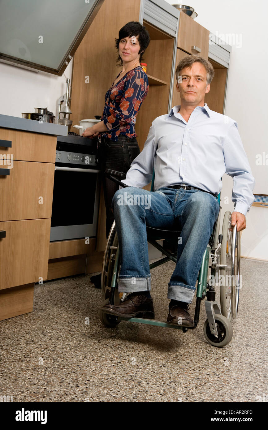 Mann und Frau in der Küche Mann im Rollstuhl Stockfoto