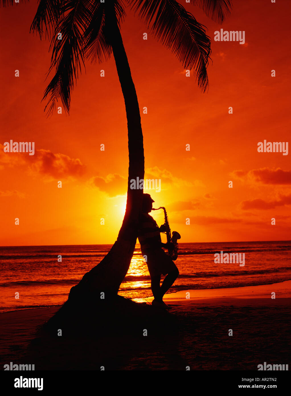 St. Lucia, Karibik. Die Silhouette des Saxophonisten am Strand bei Sonnenuntergang in den West Indies. Stockfoto