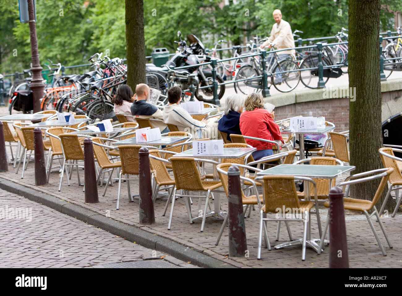 HOLLAND AMSTERDAM STREET TERRASSENCAFÉ MIT LEUTE SITZEN, ESSEN UND TRINKEN Stockfoto