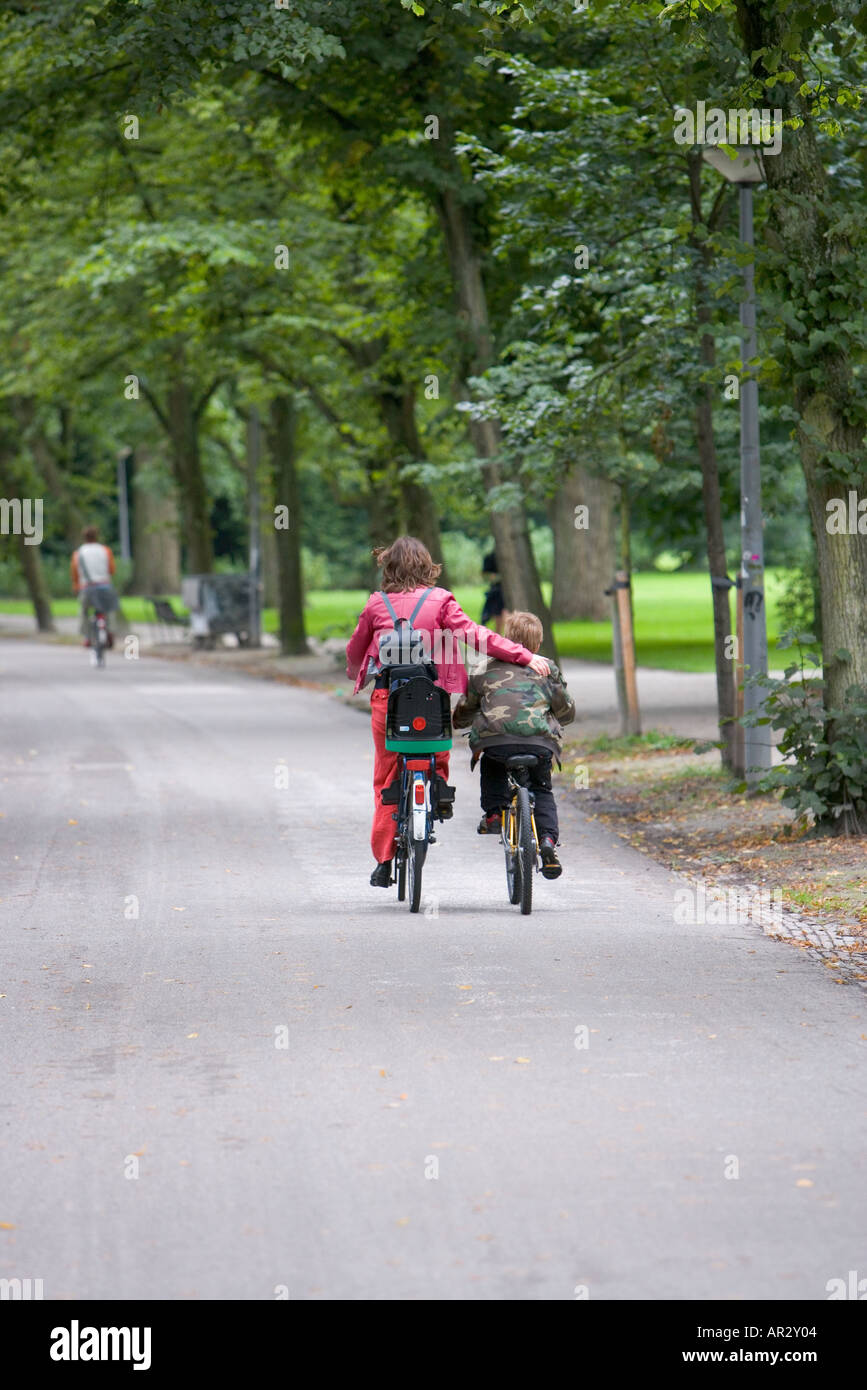 HOLLAND AMSTERDAM VONDELPARK MUTTER UND SOHN AUF DEM FAHRRAD Stockfoto