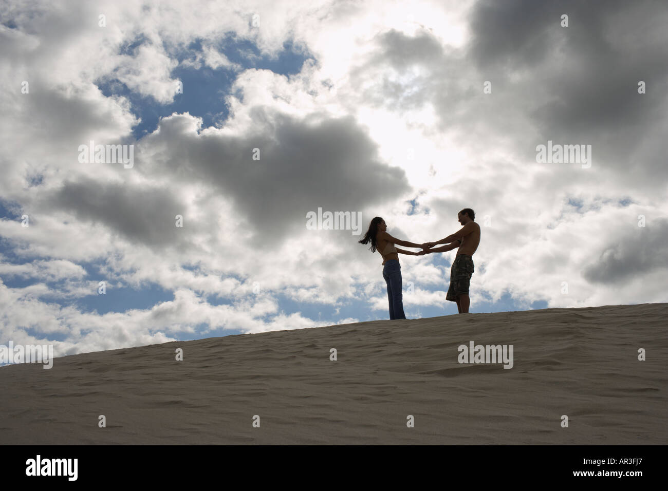 Junges Paar Hand in Hand auf Sand Düne Stockfoto