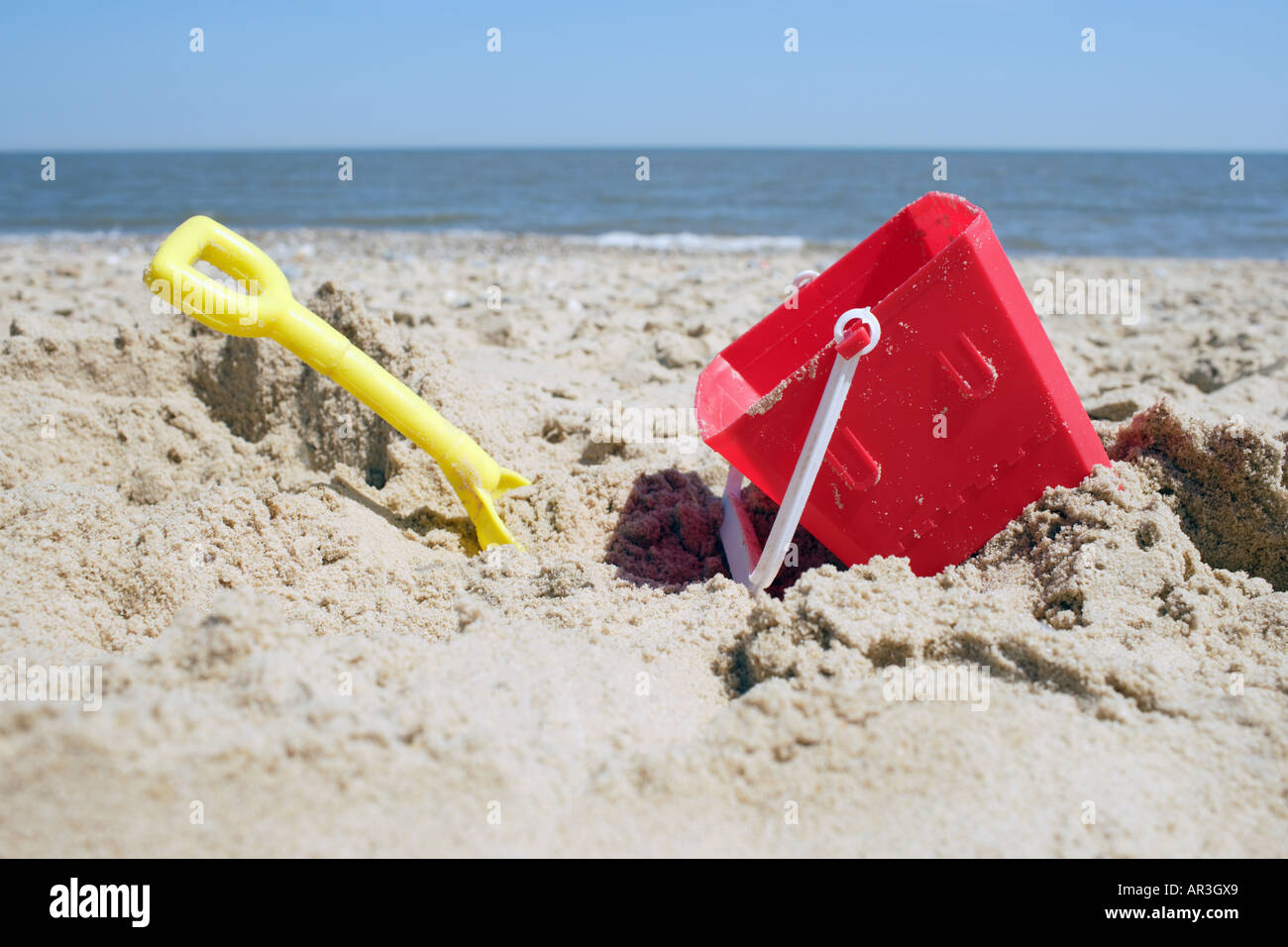 Eimer und Spaten im Sand am Strand Stockfoto