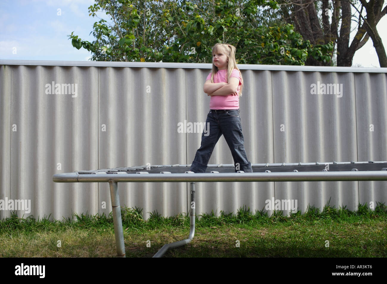 Junge Mädchen stehen auf Trampolin mit Armen gefaltet, runzelt die Stirn Stockfoto