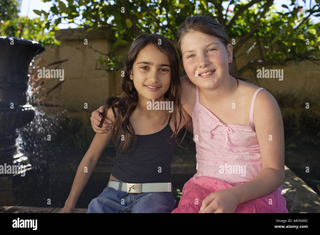 Zwei junge Mädchen Zusammensitzen im Garten Stockfoto