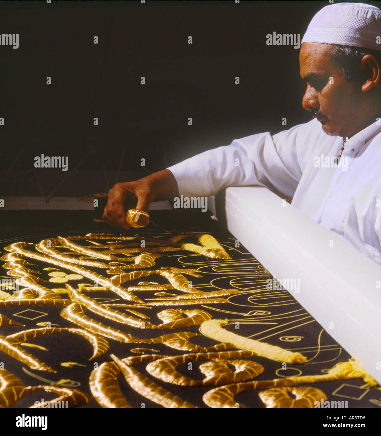 Makkah Saudi Arabien Encyclopaedia Fabrik Mann schwarzes Tuch mit Goldfaden Sticken Stockfoto