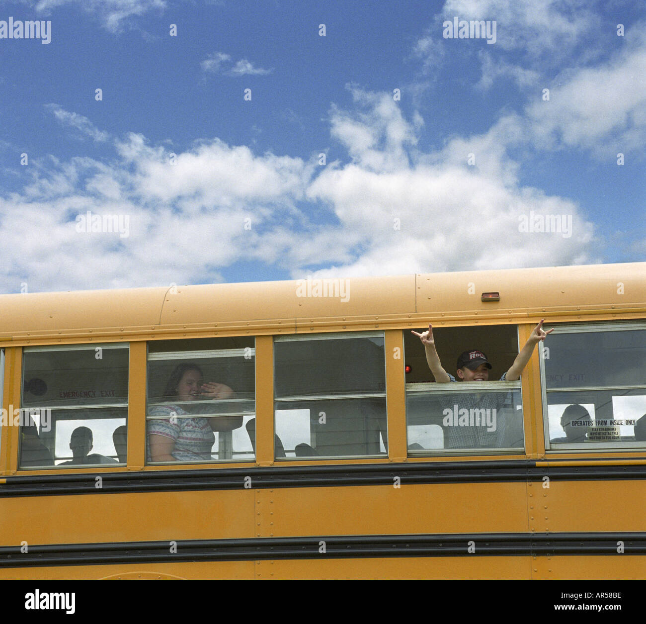 Studenten feiern als Bus zieht weg am letzten Tag der Schule Stockfoto