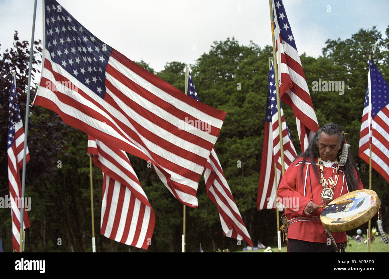 Native American spielt eine Trommel während ein Veteranen-Tag-Denkmal Stockfoto