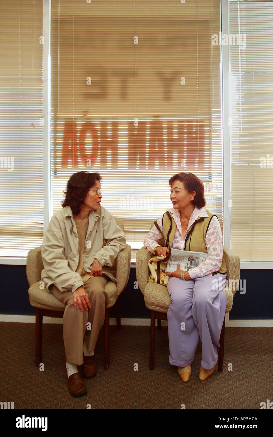 Patienten sprechen auf eine vietnamesisch-amerikanische Gemeinschaft medizinische Klinik, Garden Grove, Kalifornien, USA. Hinweis-Schild im Fenster. Stockfoto