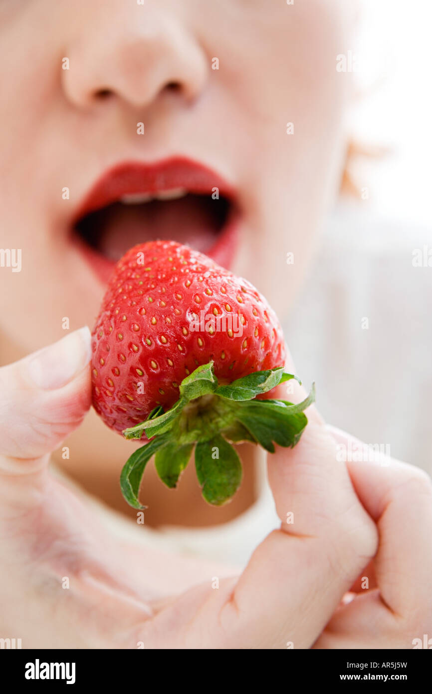 Frau eine Erdbeere essen Stockfoto