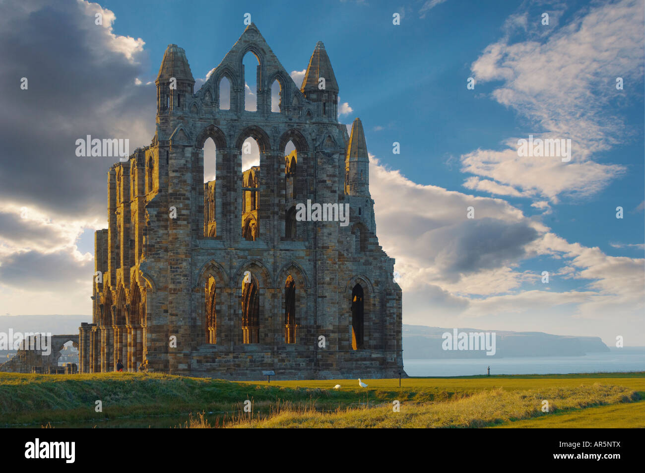 Whitby Abtei mit Grabsteinen an der Sonnenuntergang in England Stockfoto