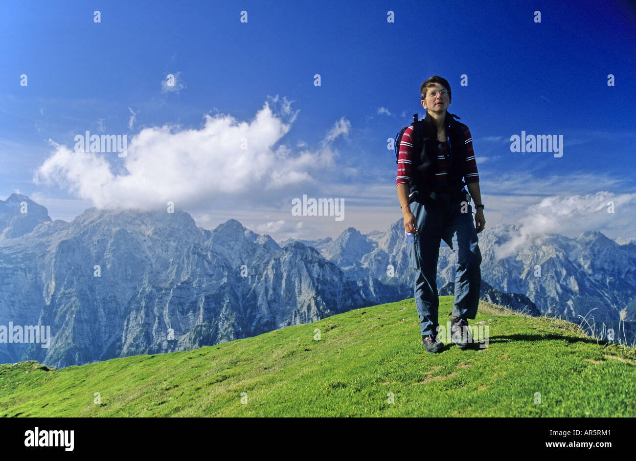 Frau Wanderungen auf einer Almwiese. Tagesklassifizierung Debela Pec, Triglav Nationalpark, im Hintergrund: Triglav, Sloweniens, Alpen. Stockfoto