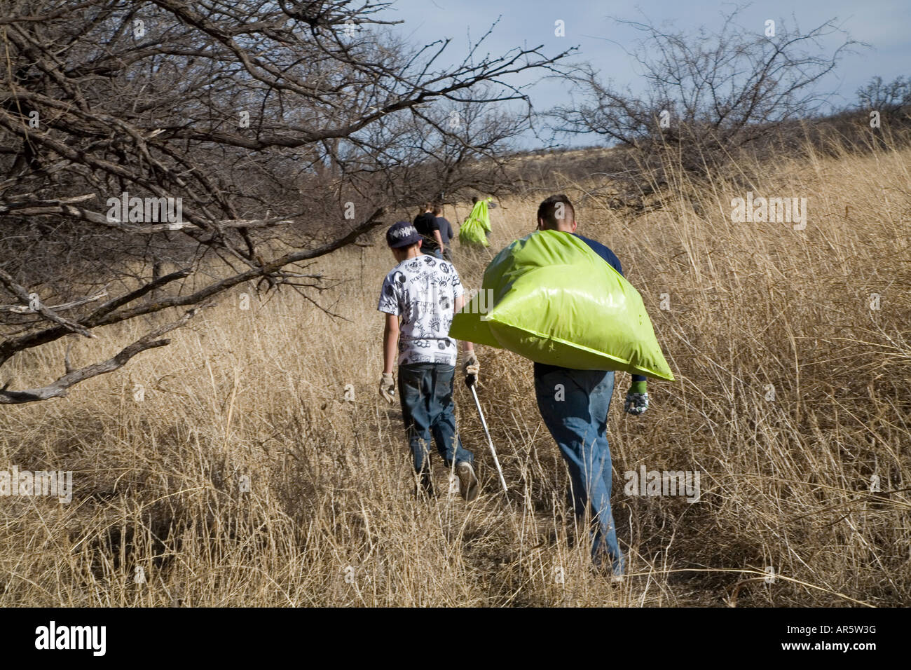 Jugendliche Freiwillige reinigen Müll links von Migrant/innen in der Wüste von Arizona Stockfoto
