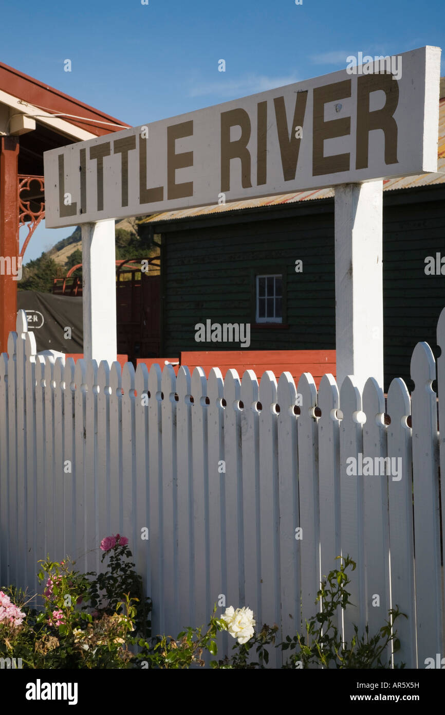 Dorf legen Namensschild auf weißen hölzernen Lattenzaun vor alten Bahnhof "Little River" New Zealand Stockfoto