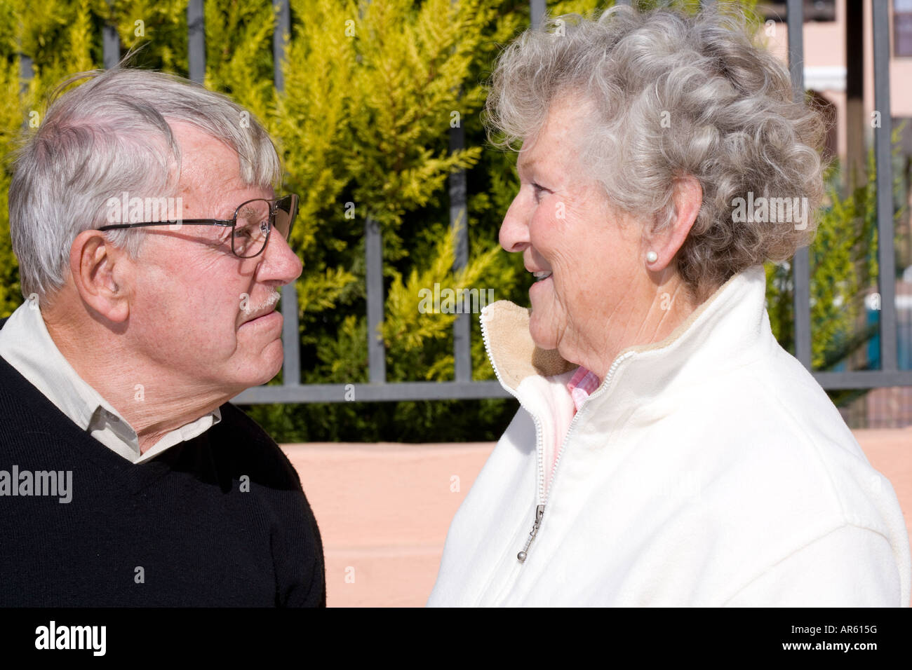 Älteres Paar einander zugewandt, mit Man zieht lustiges Gesicht auf Frau Stockfoto