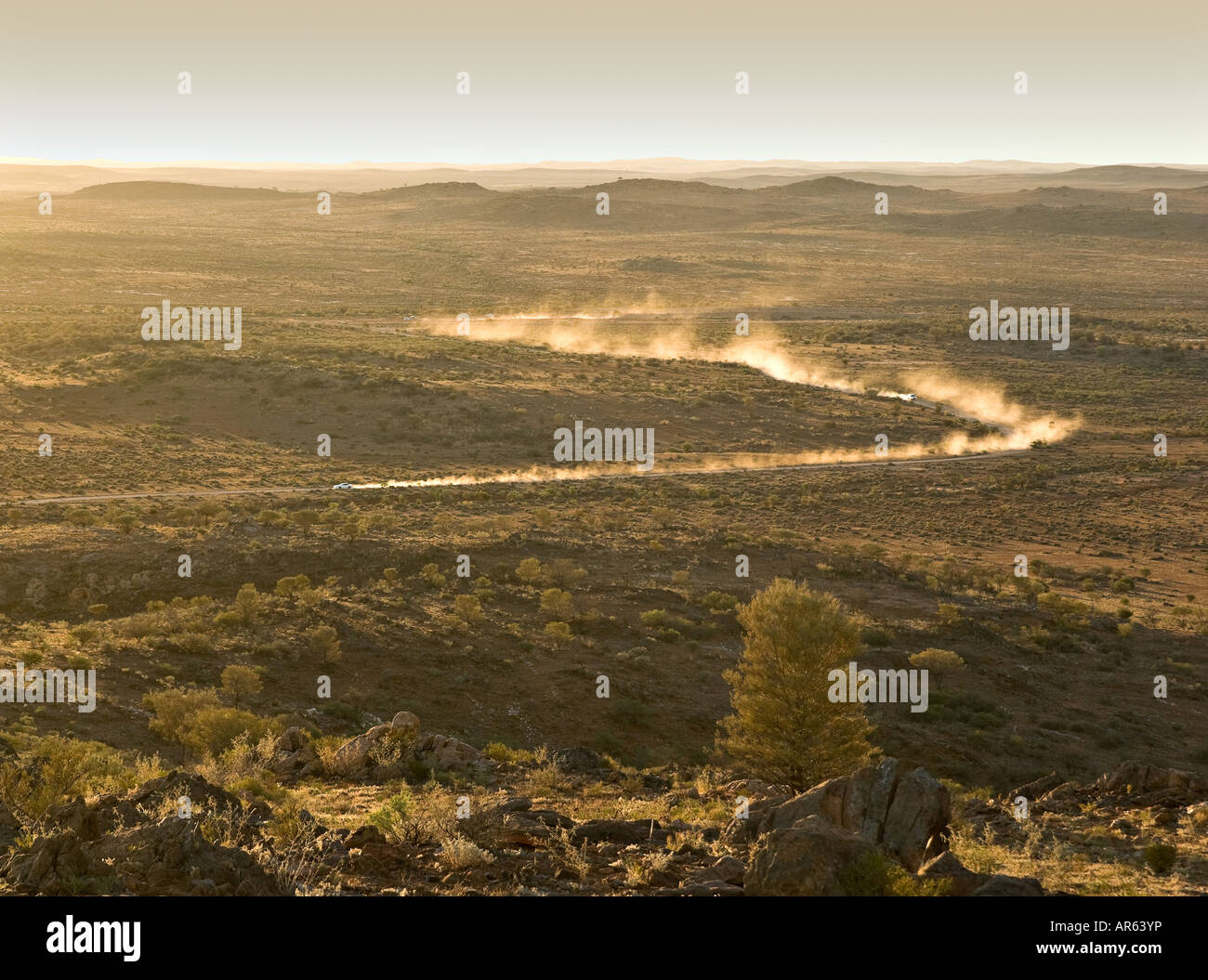 zwei Autos Federn von Staub zu verlassen, wie sie durch die Wüste bei Sonnenuntergang gehen Stockfoto
