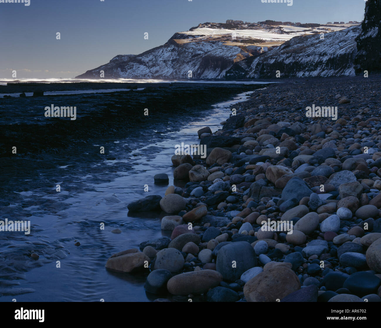 Blick entlang der felsigen Vorland unterhalb der alten Alaun arbeitet bei Stoupe Stirn auf den Schnee bedeckten Landzunge von Ravenscar Stockfoto