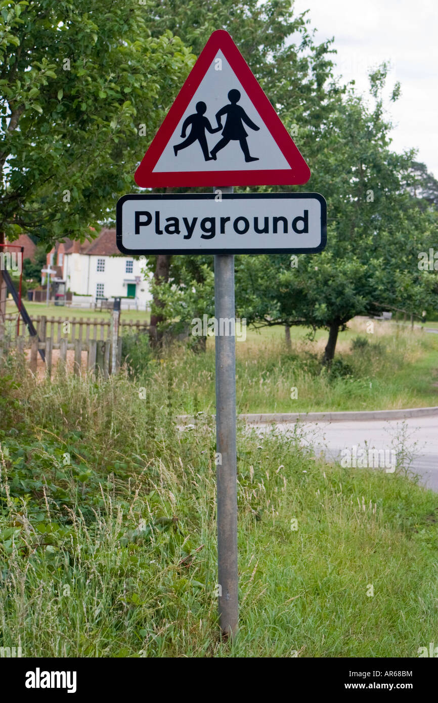 Vorsicht Kinder s Spielplatz Straßenschild mit Spielplatz im Hintergrund Stockfoto