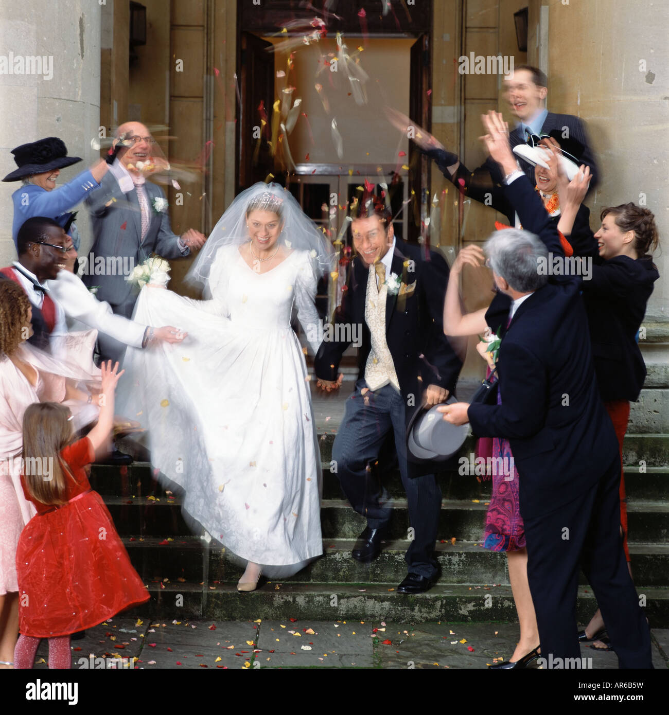 Familie und Freunde werfen Konfetti auf das Brautpaar Stockfoto