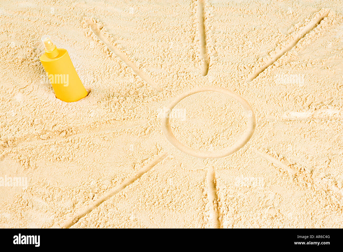 Sonnencreme und Sonne in Sand gezeichnet Stockfoto