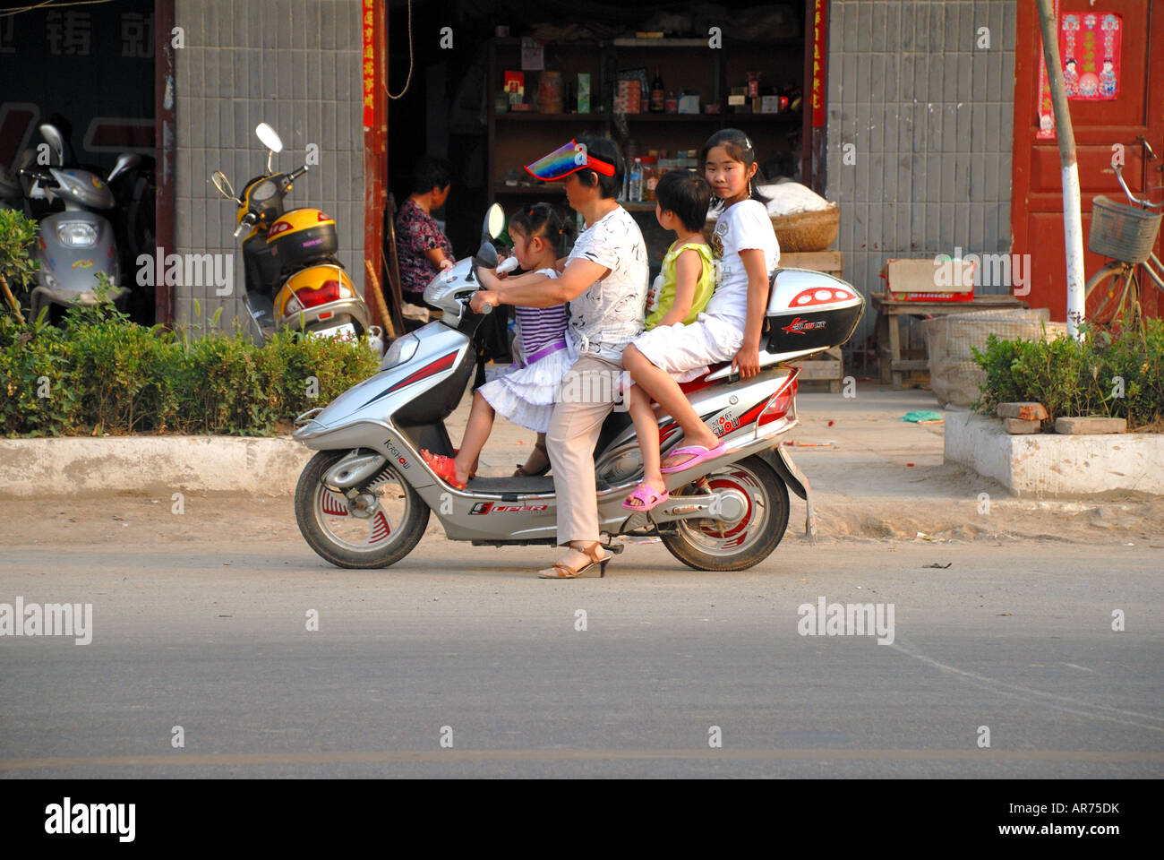 Vier Personen auf einem Motorroller unterwegs durch Taiqing Palast Quadrat Kaifeng Henan Provinz China Asien Stockfoto