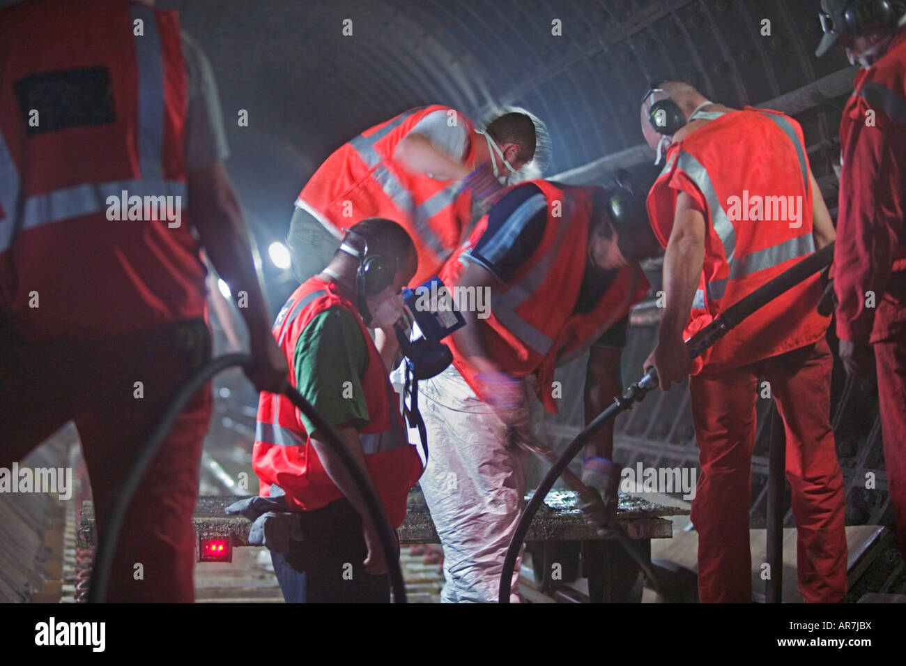 Londoner U-Bahn Arbeiter erneuern beschädigt konkrete Trassee in ein Eisenbahntunnel bei wesentlichen Nacht Wartungsarbeiten. Stockfoto
