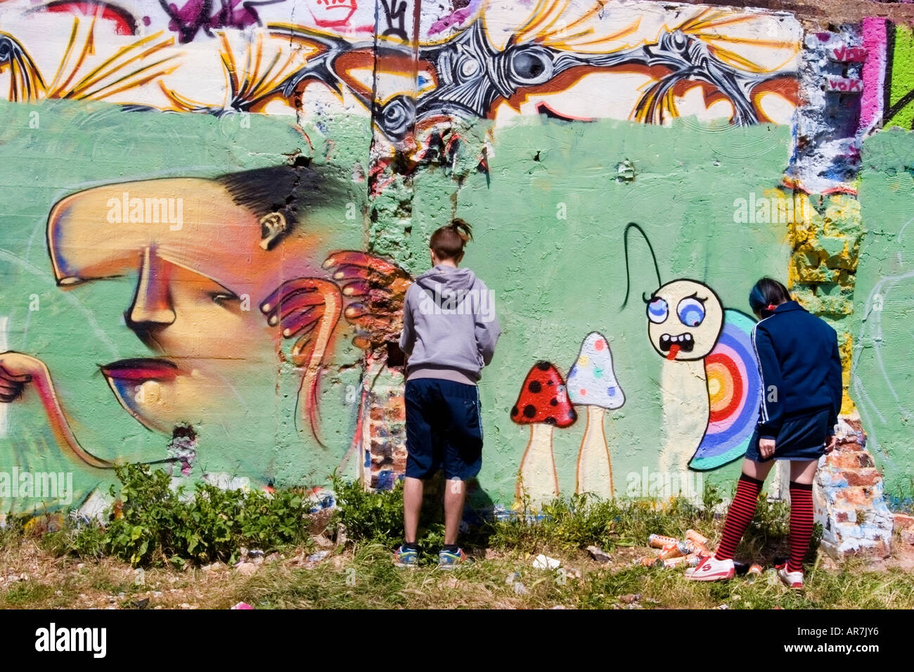 Schüler malen Graffiti entlang einer Wand in Brighton Stockfoto