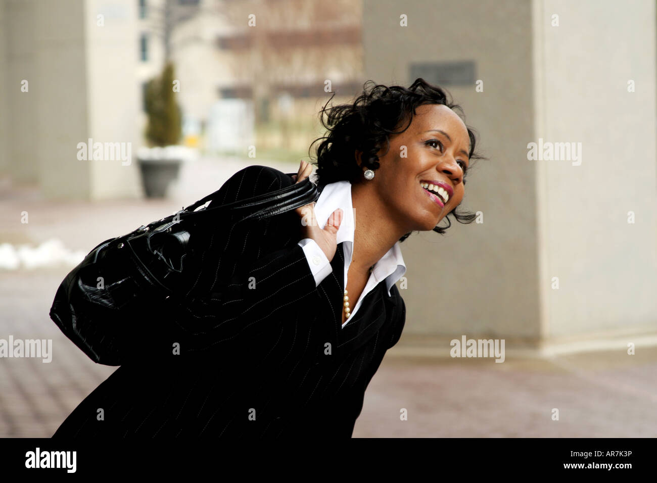 Horizontales Bild einer afrikanischen amerikanischen Business-Frau mit Handtasche über die Schulter Stockfoto